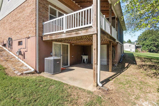 rear view of house with a patio, a yard, cooling unit, a deck, and sink