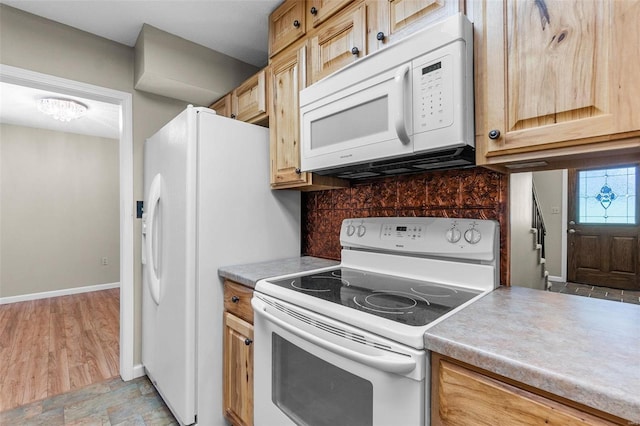 kitchen featuring light wood-type flooring, white appliances, light brown cabinets, and tasteful backsplash