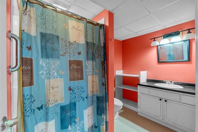 bathroom featuring curtained shower, a paneled ceiling, vanity, and toilet