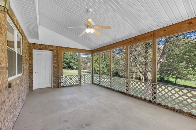 unfurnished sunroom with ceiling fan and vaulted ceiling