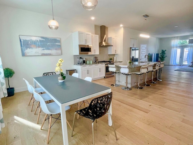 dining space with sink and light hardwood / wood-style floors