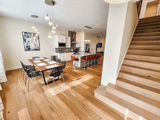 dining area with light hardwood / wood-style floors and sink