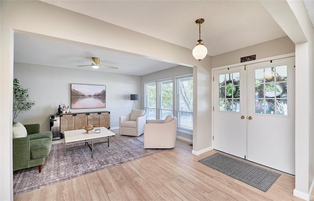 interior space with french doors, a textured ceiling, light hardwood / wood-style floors, and ceiling fan