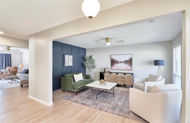 living room with a textured ceiling, hardwood / wood-style flooring, and ceiling fan