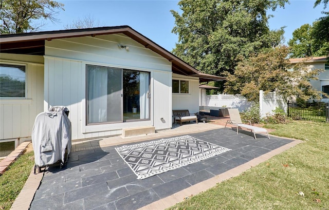 back of property featuring a lawn and a patio