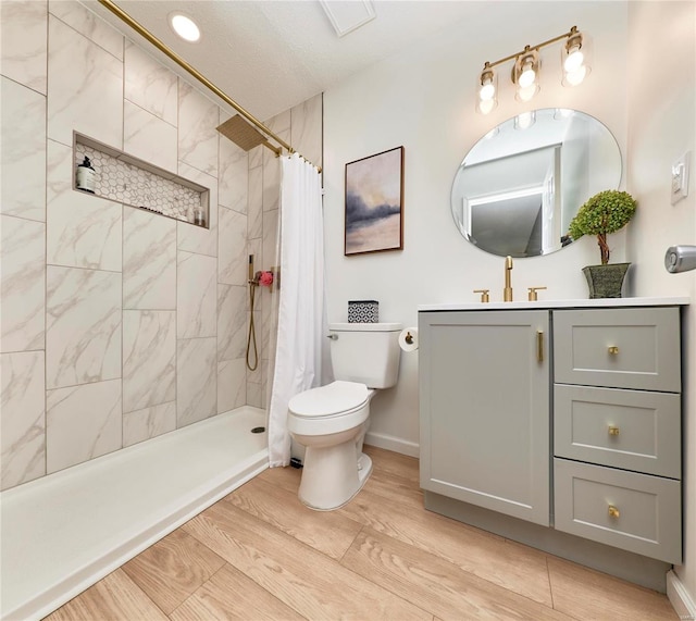 bathroom with toilet, vanity, wood-type flooring, and a shower with shower curtain