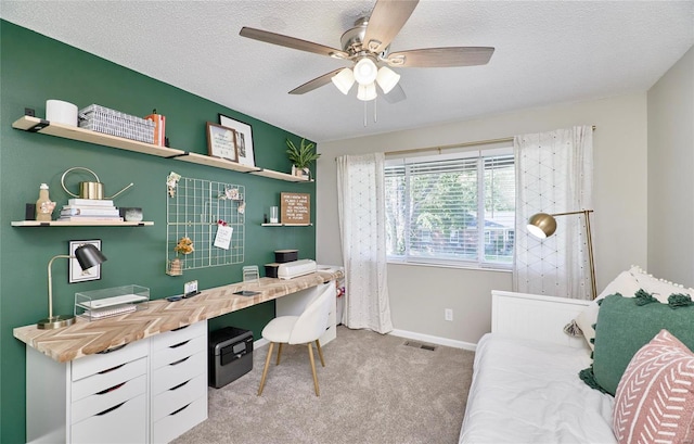 carpeted office featuring ceiling fan and a textured ceiling