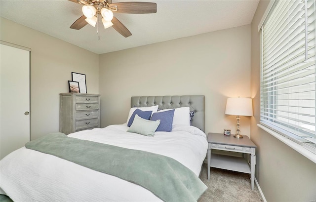 bedroom with a textured ceiling, ceiling fan, and light carpet