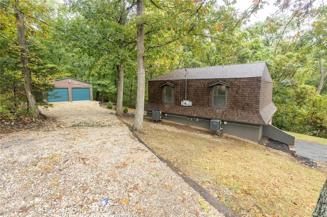 view of front of home with an outdoor structure, a garage, and central air condition unit