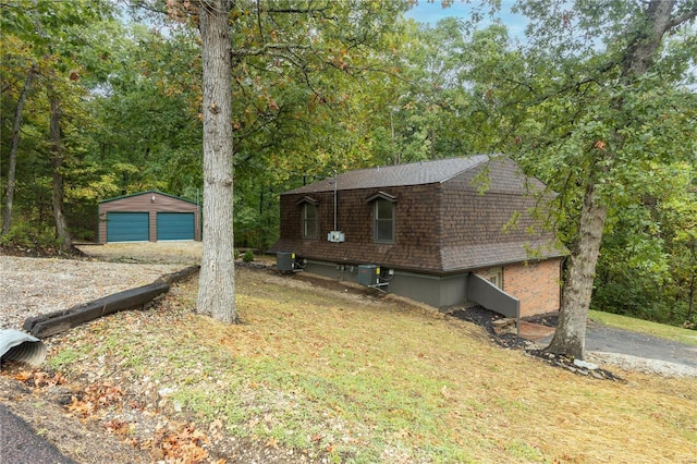 view of front of house with an outdoor structure, a garage, central air condition unit, and a front yard