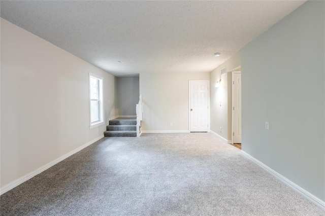 carpeted spare room featuring a textured ceiling