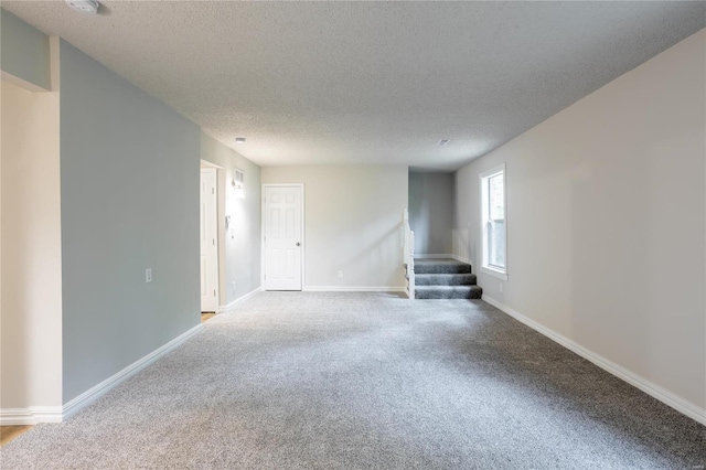 spare room with a textured ceiling and carpet flooring