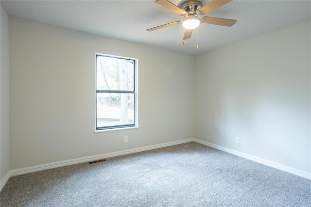 carpeted spare room featuring ceiling fan