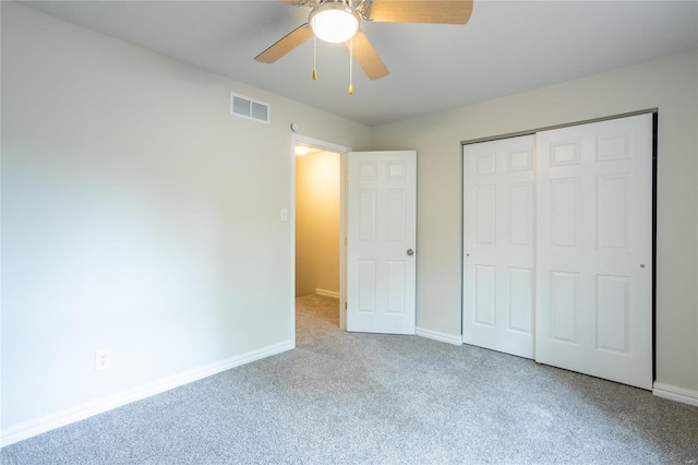 unfurnished bedroom with ceiling fan, a closet, and light carpet