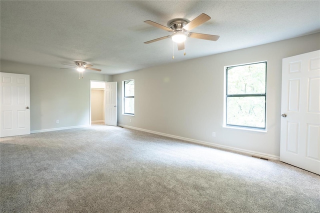 carpeted spare room featuring ceiling fan and a textured ceiling