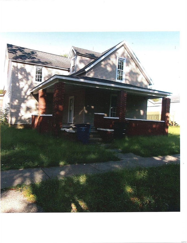 view of front facade featuring covered porch and a front yard