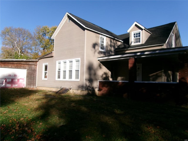 rear view of house featuring a garage and a lawn