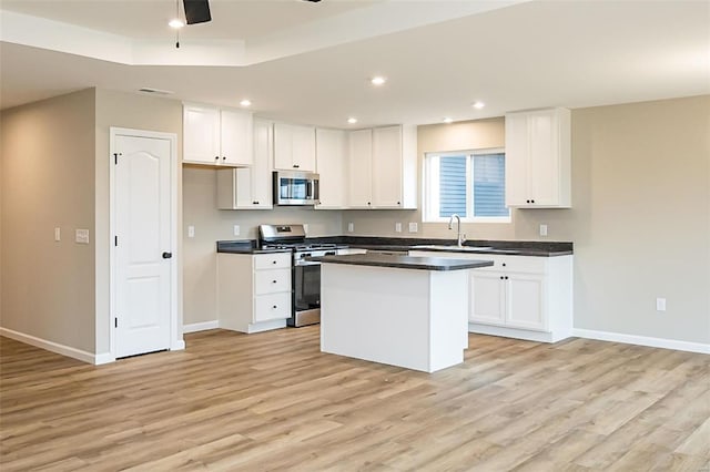 kitchen featuring sink, white cabinetry, a center island, light hardwood / wood-style flooring, and appliances with stainless steel finishes