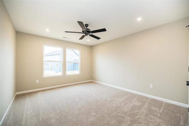 carpeted spare room with ceiling fan