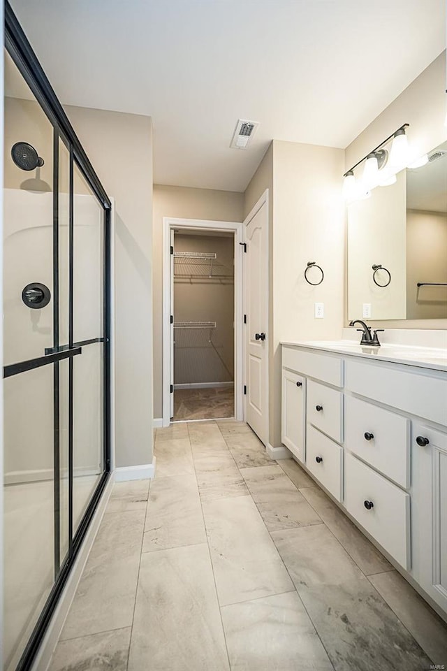 bathroom featuring vanity and a shower with door