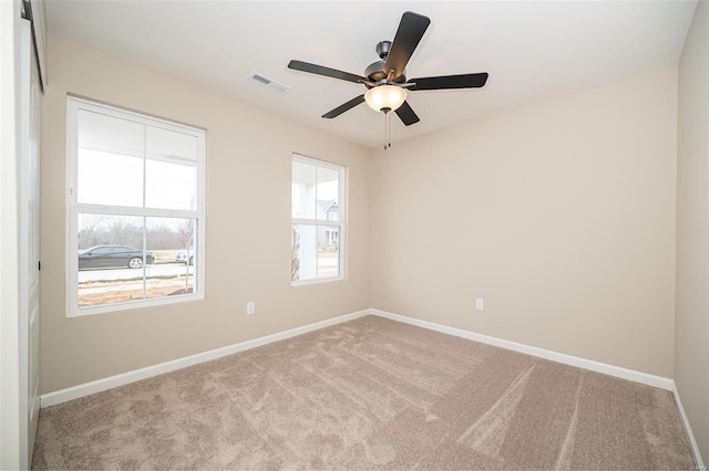 carpeted spare room with ceiling fan