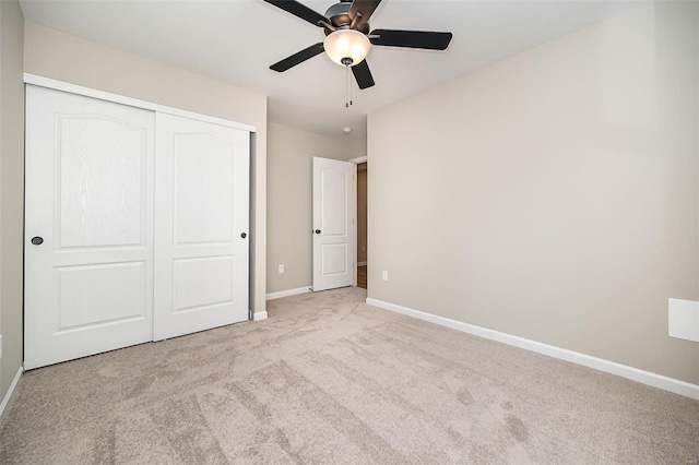 unfurnished bedroom featuring light carpet, a closet, and ceiling fan