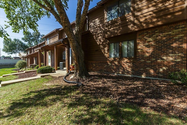 view of side of property featuring a yard and central AC unit