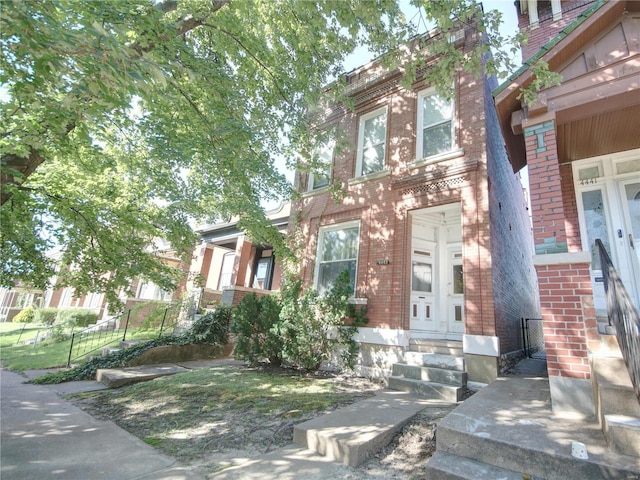 townhome / multi-family property with entry steps and brick siding