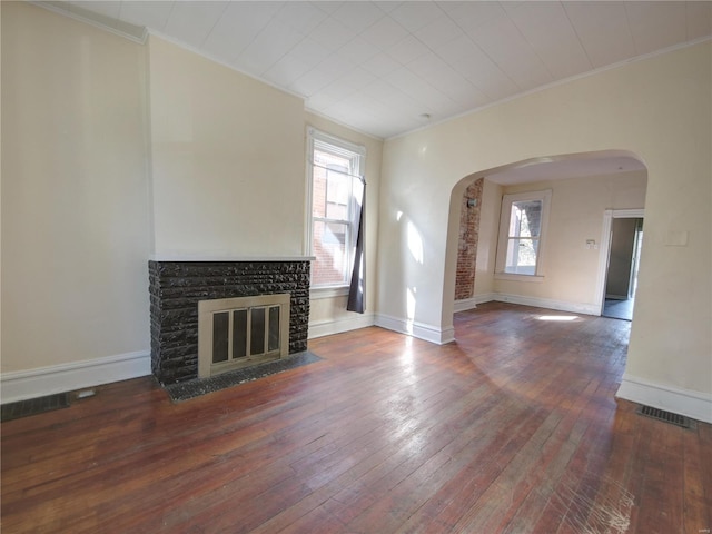 unfurnished living room featuring crown molding, a stone fireplace, and hardwood / wood-style floors