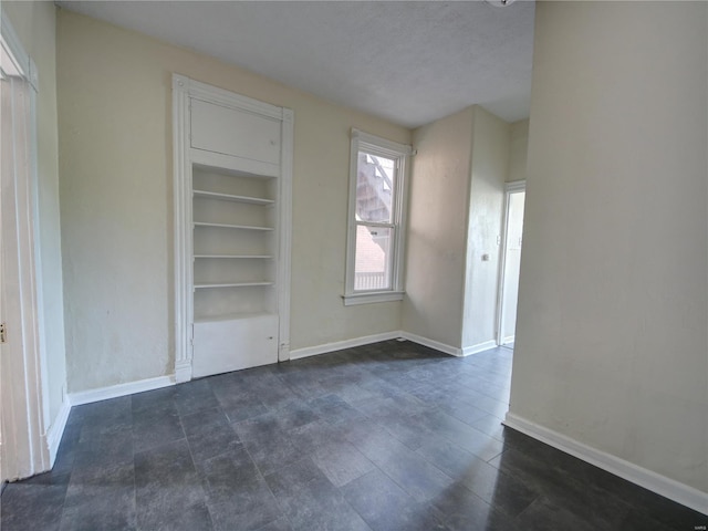 interior space with built in shelves and a textured ceiling