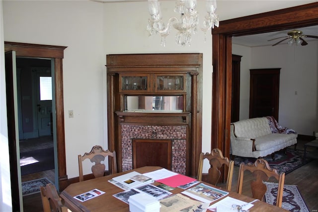 dining area with ceiling fan with notable chandelier and wood-type flooring