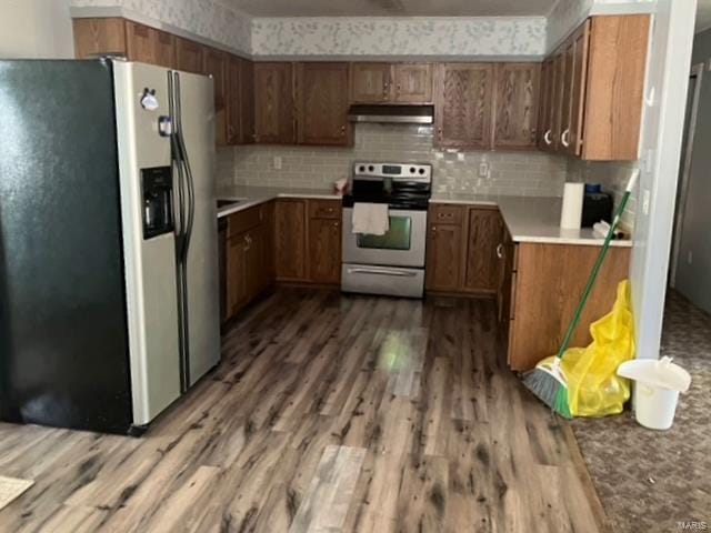 kitchen with appliances with stainless steel finishes, decorative backsplash, and hardwood / wood-style flooring