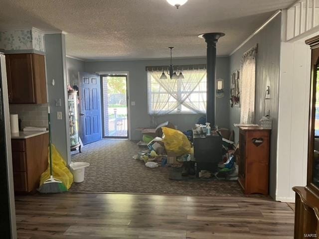 dining area with a textured ceiling, dark hardwood / wood-style floors, and crown molding