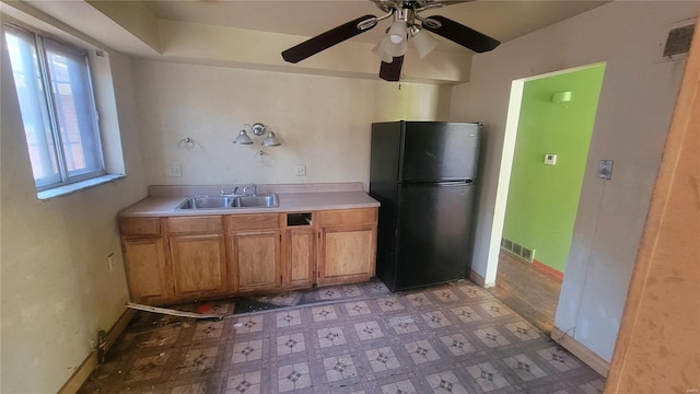 kitchen featuring sink, black fridge, and ceiling fan