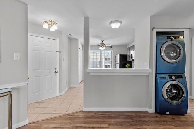 laundry area featuring stacked washer / drying machine, ceiling fan, and hardwood / wood-style flooring