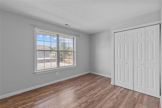 unfurnished bedroom with a closet and light hardwood / wood-style floors