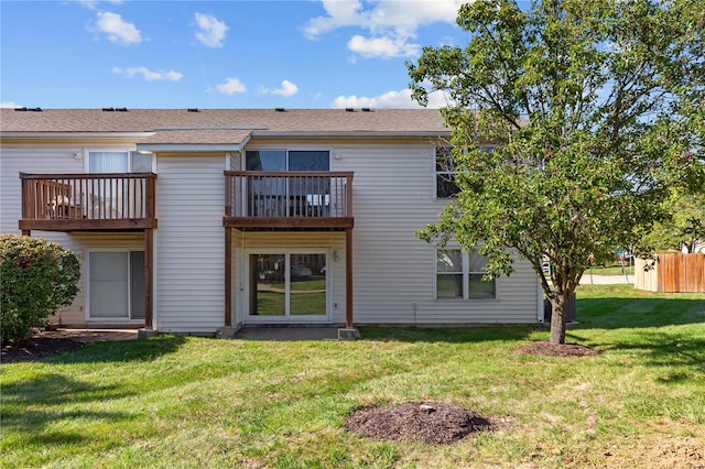 rear view of property with a balcony and a lawn