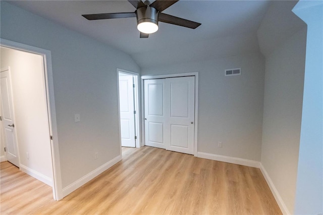 unfurnished bedroom featuring ceiling fan, a closet, lofted ceiling, and light hardwood / wood-style floors