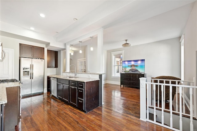 kitchen with dark hardwood / wood-style floors, appliances with stainless steel finishes, sink, and dark brown cabinetry