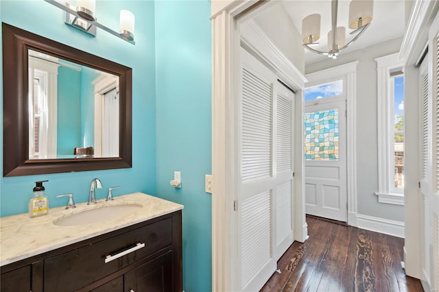 bathroom with vanity, a chandelier, and hardwood / wood-style floors