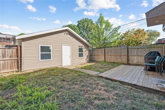 rear view of property with a deck and a lawn