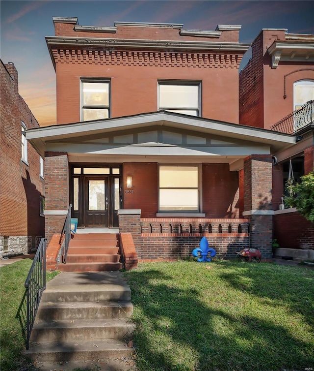 view of front of home featuring a lawn and covered porch