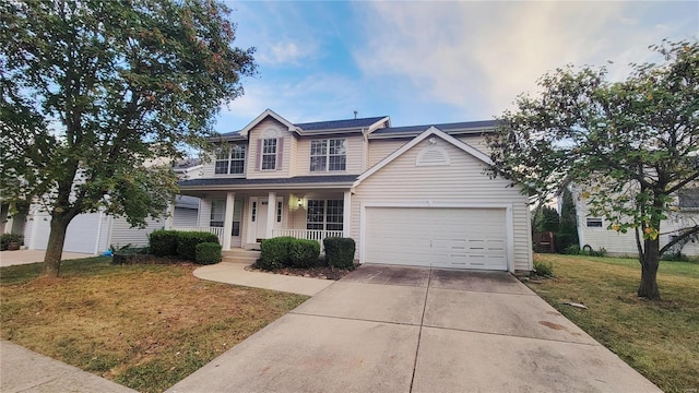 view of front of property featuring a front yard, a garage, and covered porch