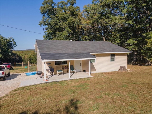 rear view of property featuring a lawn and a patio