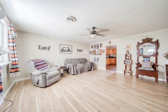 living room with light wood-type flooring and ceiling fan