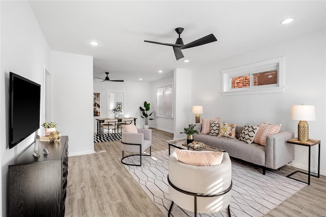 living room with ceiling fan and light hardwood / wood-style flooring