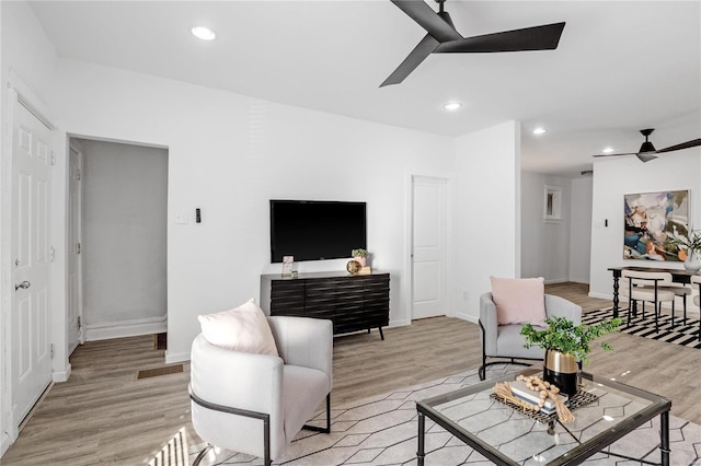 living room featuring ceiling fan and light wood-type flooring