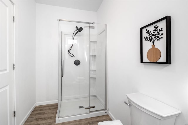 bathroom with wood-type flooring, toilet, and an enclosed shower