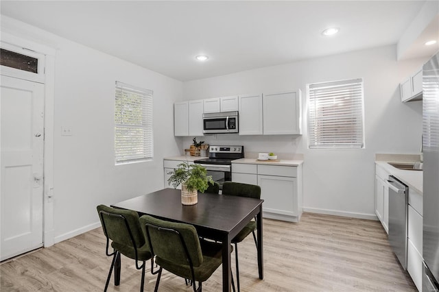 kitchen featuring light hardwood / wood-style floors, stainless steel appliances, and white cabinets