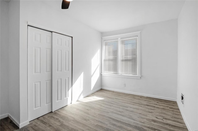 unfurnished bedroom featuring ceiling fan, a closet, and light hardwood / wood-style floors